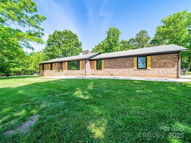 1207 Carlson Dr, Monroe, NC 28110 - view of front of house with a front yard, a chimney, and brick siding