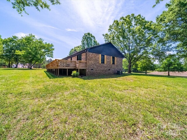 1207 Carlson Dr, Monroe, NC 28110 - view of side of property with a deck, brick siding, crawl space, and a lawn