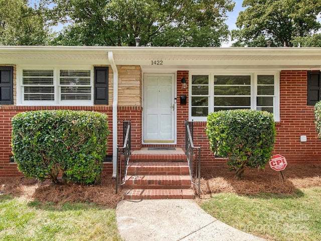 property entrance featuring brick siding