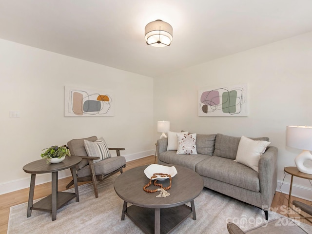 living area featuring baseboards and light wood finished floors