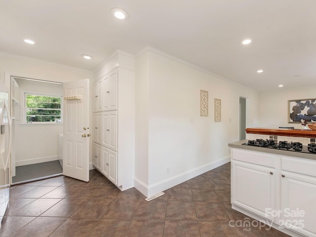 kitchen featuring crown molding, baseboards, and black gas stovetop