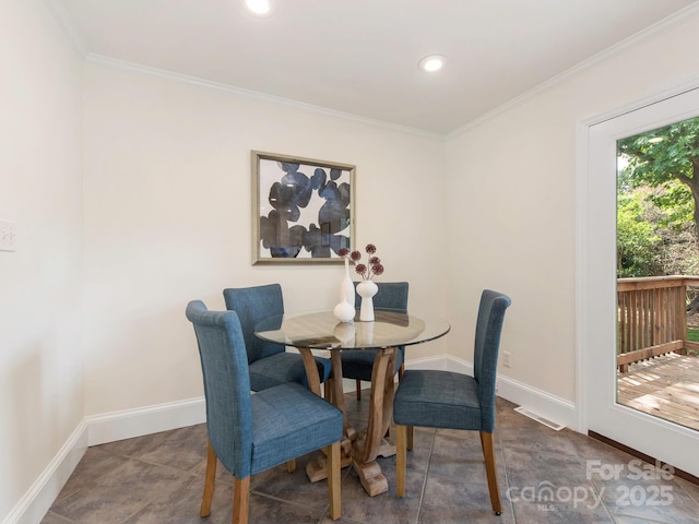 dining room with crown molding, baseboards, and visible vents