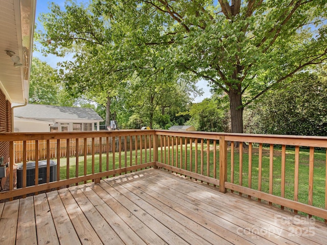 wooden deck featuring a lawn and cooling unit