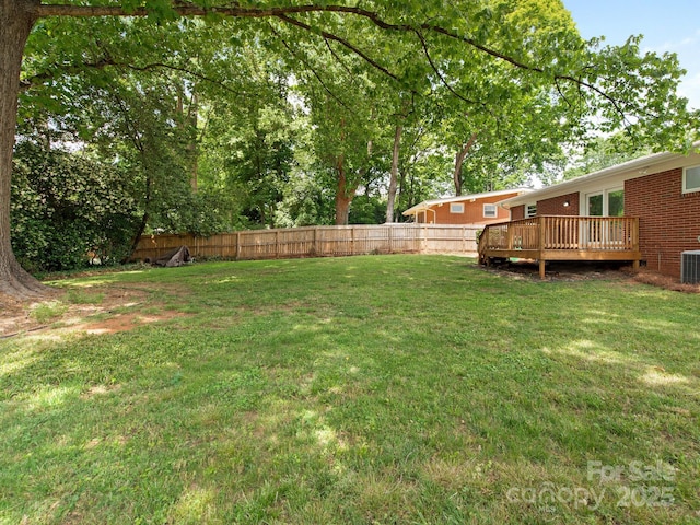 view of yard featuring central AC, a fenced backyard, and a wooden deck