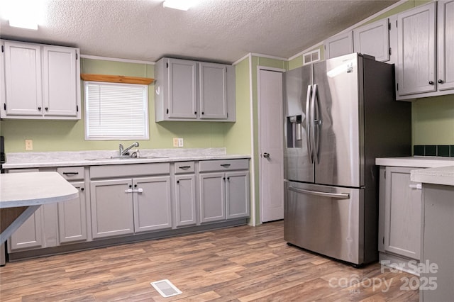 2844 Jamestown Rd Unit 2, Morganton, NC 28655 - kitchen featuring a sink, stainless steel fridge, light countertops, a textured ceiling, and light wood-type flooring