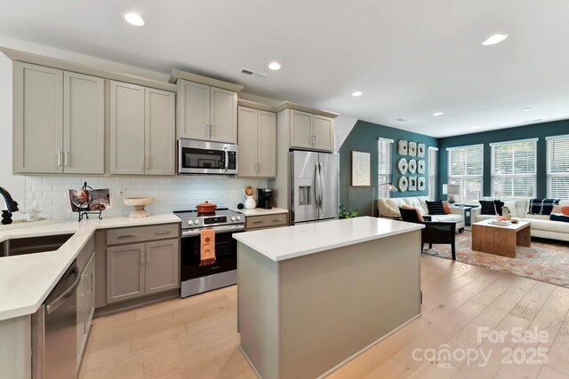 316 S Turner Ave Unit 11, Charlotte, NC 28208 - kitchen featuring visible vents, open floor plan, a sink, gray cabinetry, and stainless steel appliances