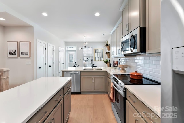 316 S Turner Ave Unit 11, Charlotte, NC 28208 - kitchen featuring light countertops, gray cabinets, a sink, light wood-style flooring, and stainless steel appliances