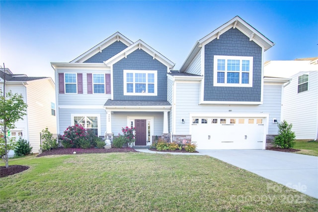 craftsman-style home featuring an attached garage, driveway, and a front lawn