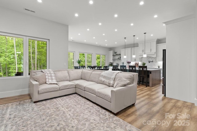 living room with recessed lighting, visible vents, and light wood-style floors