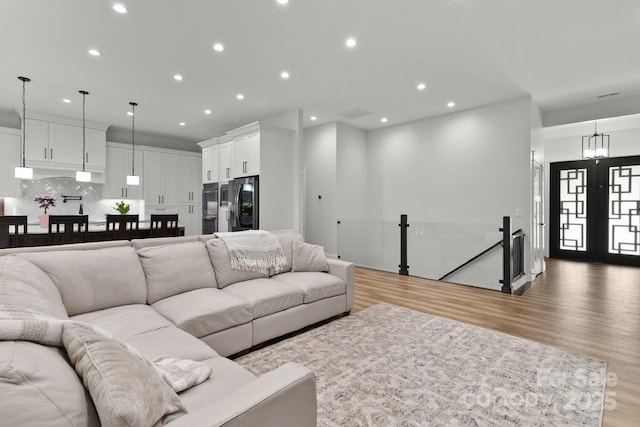 living area with light wood-type flooring and recessed lighting
