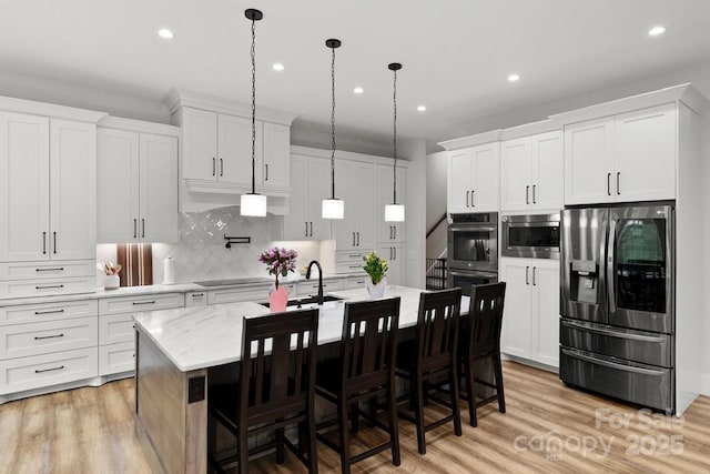 kitchen with appliances with stainless steel finishes, tasteful backsplash, recessed lighting, and light wood-style flooring