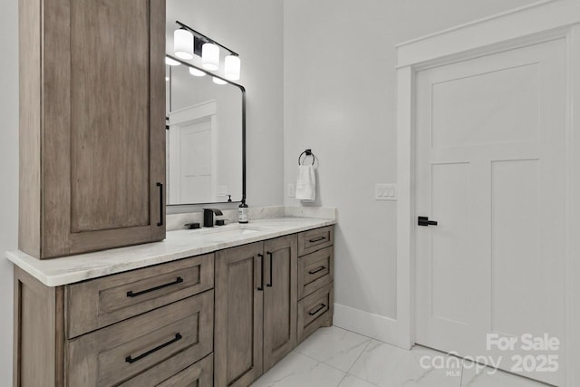 bathroom with baseboards, vanity, and marble finish floor