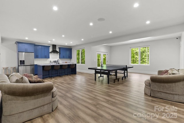 rec room featuring recessed lighting, baseboards, french doors, and light wood-style floors