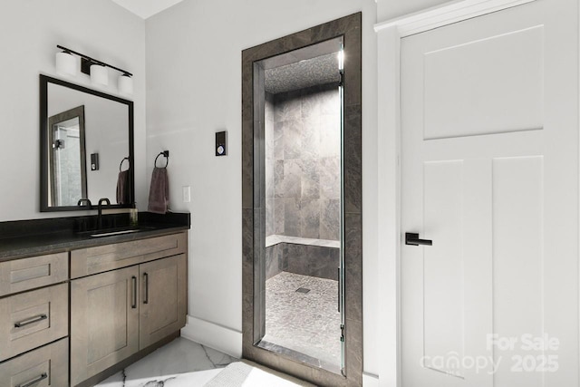bathroom with a shower stall, marble finish floor, and vanity