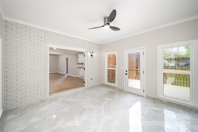 spare room with crown molding, ceiling fan, brick wall, and marble finish floor