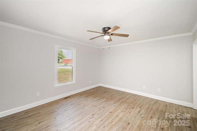 empty room with crown molding, baseboards, ceiling fan, and wood finished floors