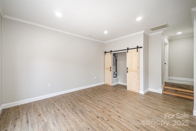 unfurnished bedroom with visible vents, a barn door, baseboards, light wood-style floors, and recessed lighting