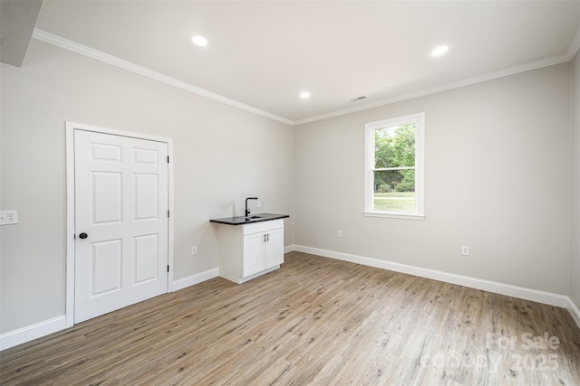 unfurnished room featuring recessed lighting, baseboards, crown molding, and light wood-type flooring
