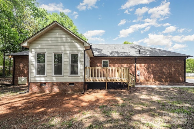 back of property with crawl space, roof with shingles, and a deck