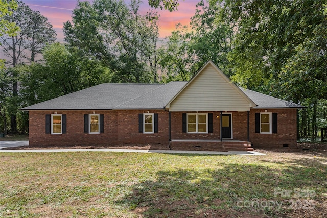 single story home featuring a porch, brick siding, a front yard, and roof with shingles