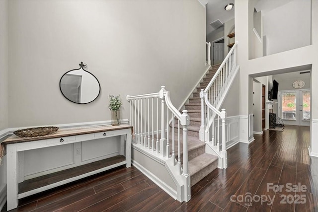 staircase with wood finished floors and french doors