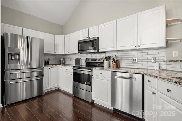 kitchen with appliances with stainless steel finishes, open shelves, tasteful backsplash, light stone countertops, and white cabinetry