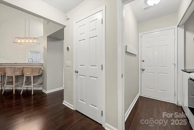 hallway with wood finished floors and baseboards