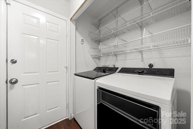 laundry room with separate washer and dryer and dark wood finished floors
