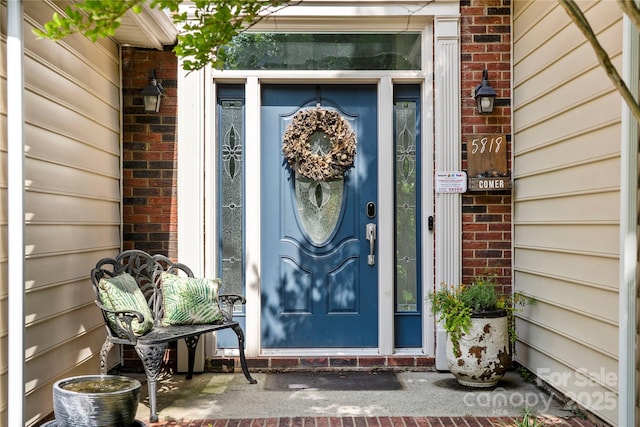 doorway to property featuring brick siding