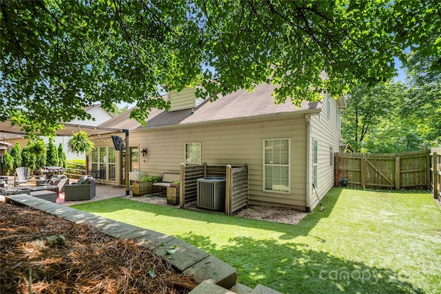rear view of property with central AC unit, a shingled roof, a patio area, and a gate