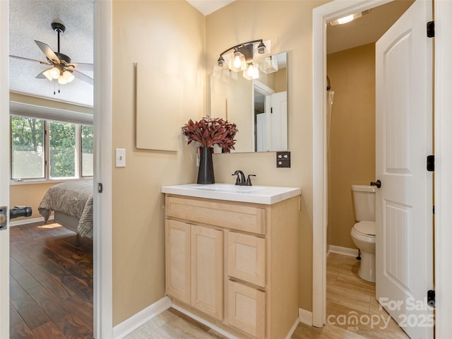 23 Hollybrook Dr, Asheville, NC 28803 - full bathroom featuring vanity, wood finished floors, toilet, baseboards, and a ceiling fan