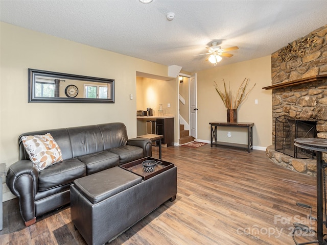 23 Hollybrook Dr, Asheville, NC 28803 - living area with ceiling fan, a fireplace, a textured ceiling, wood finished floors, and stairway