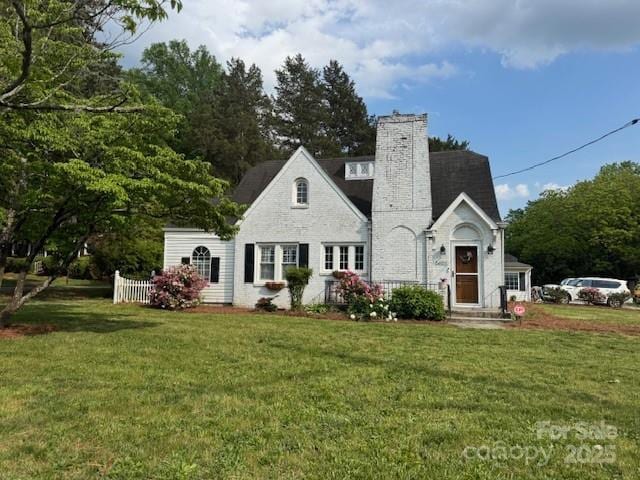 back of property with a chimney and a yard
