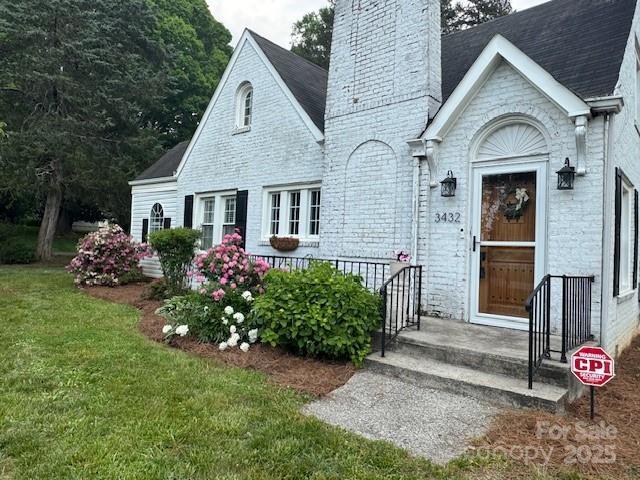 view of front of property featuring a chimney and a front yard