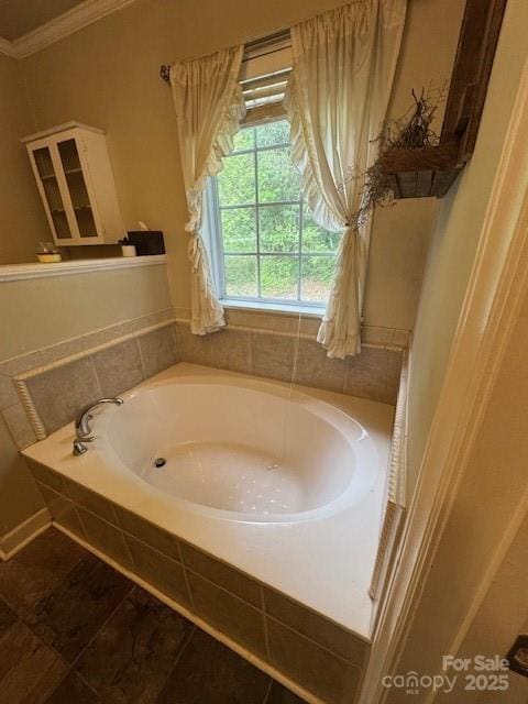 bathroom featuring tile patterned floors, ornamental molding, and a garden tub