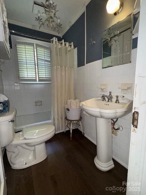 full bath with curtained shower, wood finished floors, toilet, tile walls, and a notable chandelier