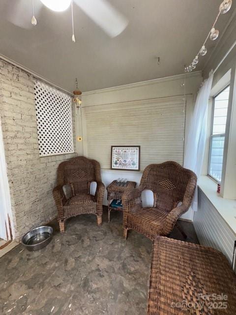 sitting room featuring crown molding and brick wall