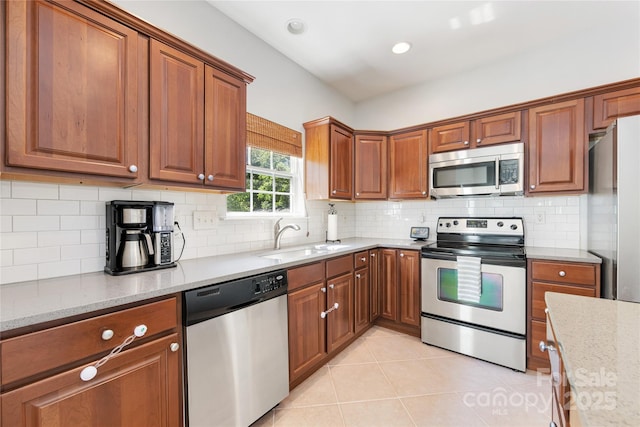 1728 Privette Rd, Matthews, NC 28105 - kitchen with appliances with stainless steel finishes, a sink, light stone countertops, and brown cabinetry