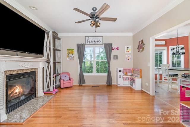 game room with plenty of natural light, baseboards, ceiling fan with notable chandelier, and wood finished floors