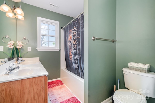 bathroom with double vanity, toilet, visible vents, and a sink