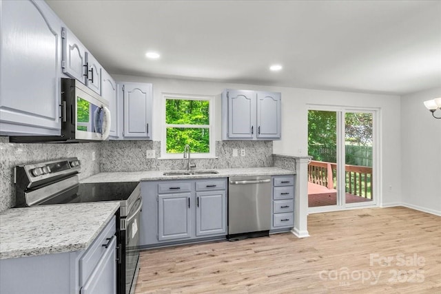 6839 Wagon Oak Rd, Charlotte, NC 28212 - kitchen with a sink, stainless steel appliances, gray cabinets, light wood-style flooring, and backsplash