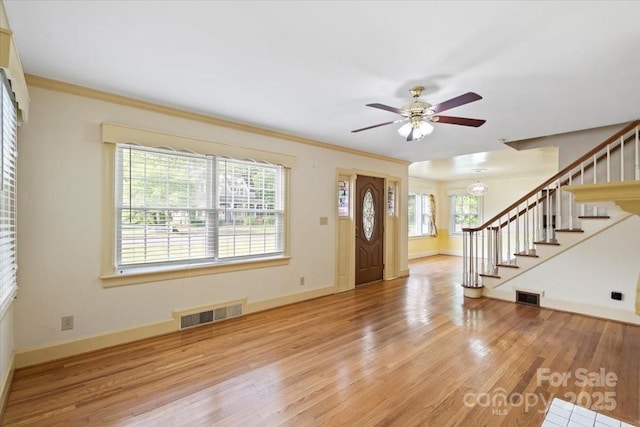 foyer entrance featuring stairs, ceiling fan, visible vents, and wood finished floors