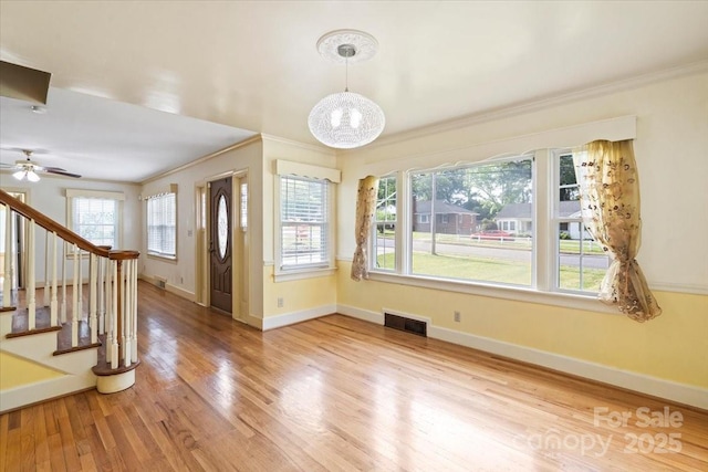 foyer entrance with baseboards, ornamental molding, and wood finished floors