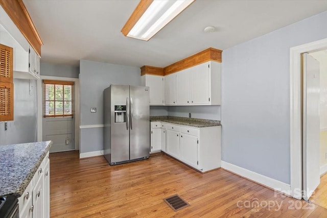 kitchen with visible vents, light wood-type flooring, baseboards, and stainless steel appliances