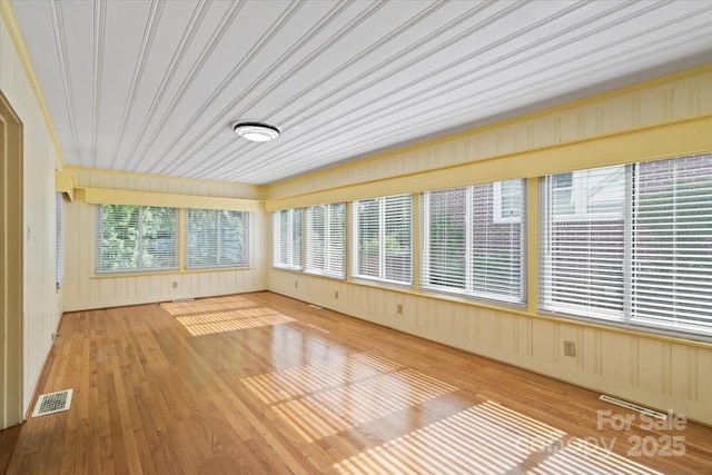 unfurnished sunroom with wood finished floors and visible vents