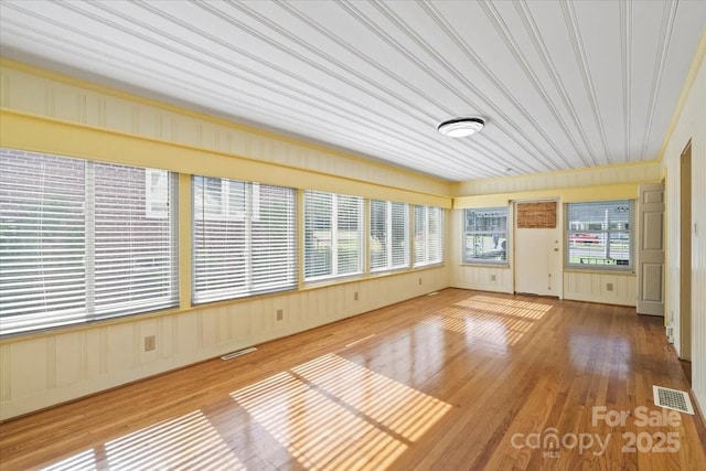 unfurnished sunroom with visible vents and wood finished floors