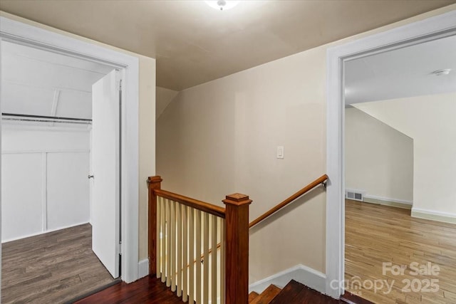 stairs with visible vents, baseboards, and wood finished floors