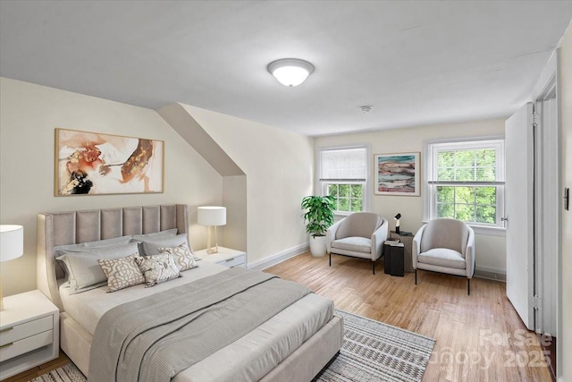 bedroom featuring baseboards and light wood finished floors