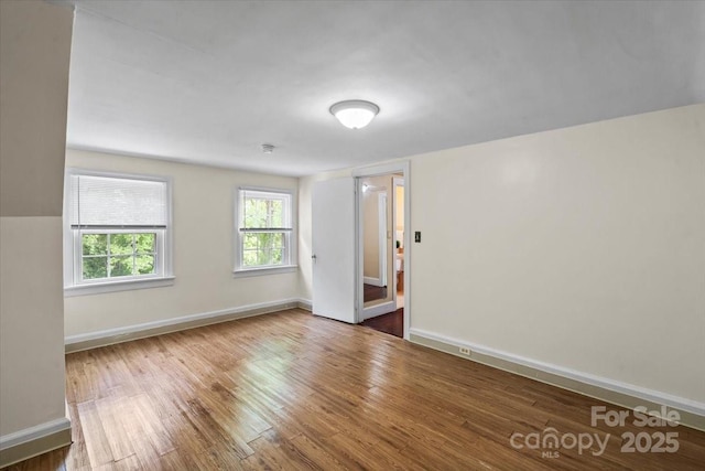 unfurnished room featuring baseboards and wood finished floors