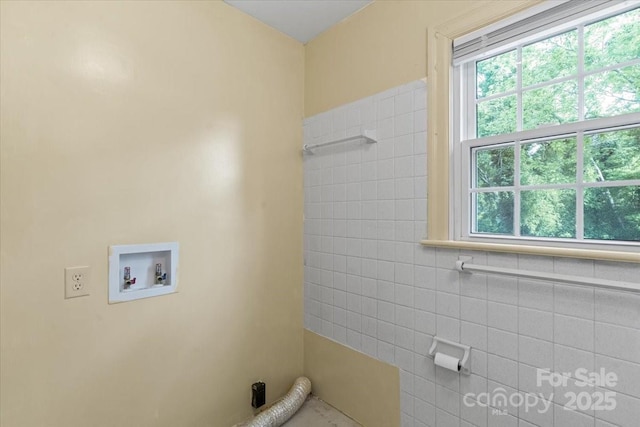 laundry area with laundry area, tile walls, and hookup for a washing machine
